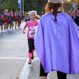 A participant in Get Healthy, Live Well’s 1-mile Superhero Fun Run prepares to cross the finish line.